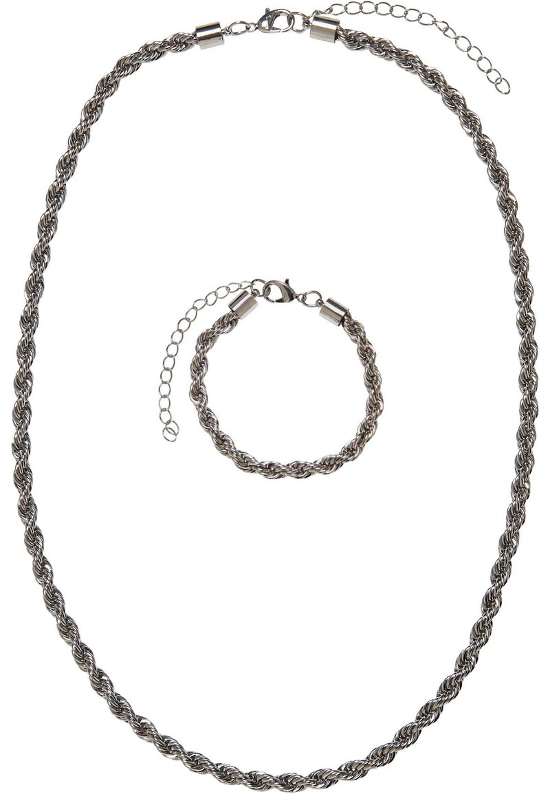 Conjunto de collar y pulsera tono plateado, que presenta un diseño de cuerda retorcida con un acabado liso. Ambas piezas tienen cierres de metal y cadenas de extensión.