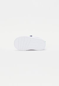 Fehér sneaker talpa mintás talprész, lekerekített forma és diszkrét márkajelzés. Texturált gumival rendelkezik a tapadás és stabilitás érdekében.