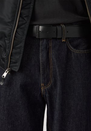 Black zippered jacket, dark blue denim jeans with orange stitching, and a black belt are displayed in the image.