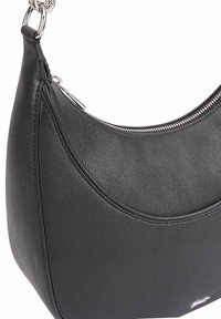 Zwarte leren schoudertas met een gebogen ontwerp, ritsluiting en accenten van zilverkleurig metaal. Textuur oppervlakte met een gladde afwerking.