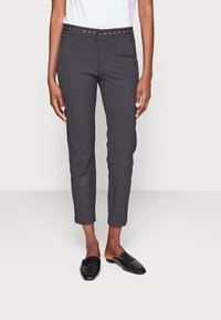 Grijze op maat gemaakte broeken met een slim fit, cropped lengte en een gespannen zwarte riem. Gemaakt in combinatie met zwarte instaploafers. Eenvoudig ontwerp en textuur.