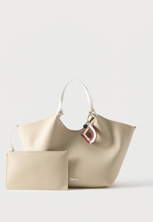 Beige DKNY tote taske med hvide håndtag, en aftagelig matchende pung og en rød- og hvid nøglering.