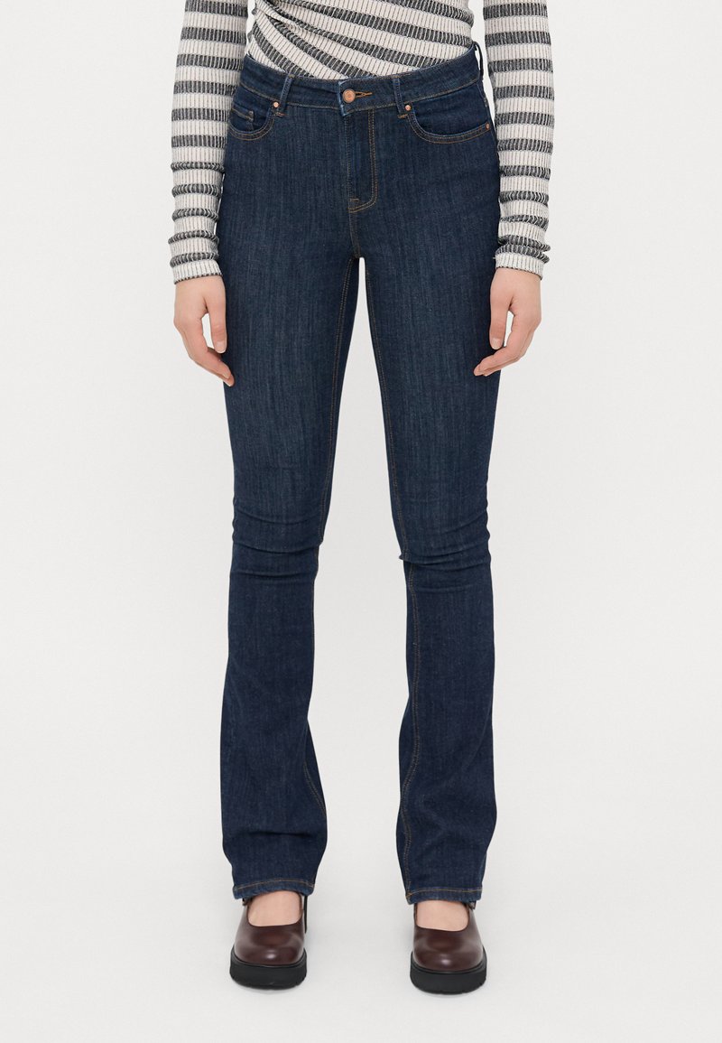 Σκούρο τζιν παντελόνι με φαρδιά γραμμή, με διακριτές ραφές, πέντε τσέπες, κλείσιμο με κουμπί και εφαρμοστή σιλουέτα μέχρι τα γόνατα.