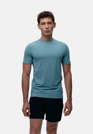 Camiseta deportiva de manga corta en un tono azul claro, hecha de un tejido que absorbe la humedad, presenta un escote redondo y elementos de diseño sutiles.