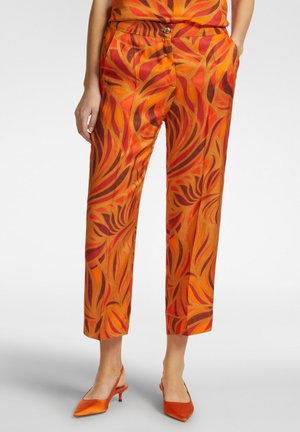 Pantaloni colorati in arancione, rosso e marrone con un motivo floreale fluido. Presentano una chiusura con bottone e tasche laterali. Design a lunghezza cropped.