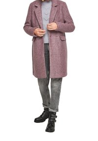 Lungo cappotto morbido in misto lana di colore rosa con colletto a scollo, bottoni frontali e tasche laterali, abbinato a un maglione grigio in maglia e jeans grigi.