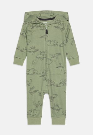 Grüner, mit Dinosaurier-Muster bedruckter Einteiler mit Reißverschluss vorne und Kapuze. Rippstruktur und Bündchen; vorne mit Taschen ausgestattet.