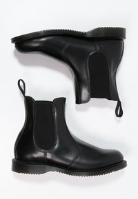 Czarne skórzane botki Chelsea z teksturowanymi elastycznymi panelami bocznymi, płaskimi gumowymi podeszwami i uchwytami na pięcie ułatwiającymi zakładanie.