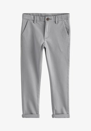 Close-up van gevouwen grijze stoffen mouwen met geribde manchetten en zichtbare stiksels op een lichte achtergrond.