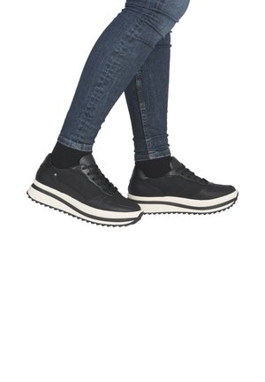Black leather sneakers with a thick white midsole and textured rubber outsole, featuring laces and subtle branding on the side.