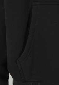 Čierna látka mikiny s hladkým povrchom, obsahujúca bočné vrecko a rebrované manžety, s čistým prešívaním po celom povrchu.