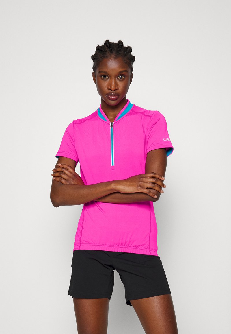 Rosa kurzärmeliges Sportoberteil mit Reißverschlusskragen und türkisfarbenen Akzenten. Trägt man mit schwarzen Shorts, die ein figurbetontes Design und eine glatte Textur betonen.