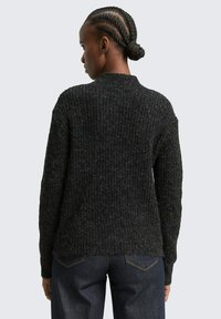 Donkergrijze gebreide trui met een textuurpatroon, ronde halslijn en lange mouwen. Draag het met donkere jeans met een relaxte pasvorm.