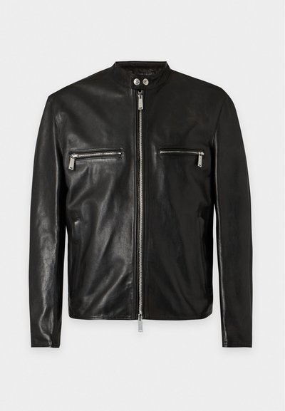 Veste en cuir noire avec fermeture éclair à l'avant, deux poches zippées horizontales sur la poitrine, col montant avec deux boutons-pression argentés et manches longues.