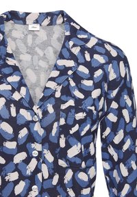 Maglietta da pigiama blu navy con un motivo a pennellate di colore blu e bianco, colletto a scollatura a V, taschino e chiusura con bottoni. Tessuto morbido.