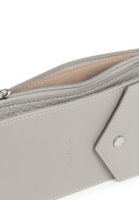 Portafoglio in pelle grigia chiaro con zip parzialmente aperta, interno in tessuto beige e tasca anteriore con bottone a scatto in dettaglio argentato.