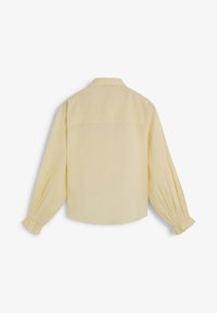 Bluză galbenă cu mânecă lungă, guler de cămașă, manșete elasticizate și tiv drept. Textură netedă și design minimalist, vedere din spate.