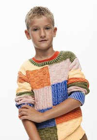 Maglione lavorato a maglia con design patchwork nei colori arancione, blu, verde, rosa e giallo. Pattern testurizzati creano un interesse visivo con polsini a coste.