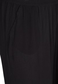 Pantalons noirs en tissu léger avec une surface texturée et un design plissé, dotés de poches latérales. Taille élastique pour le confort.