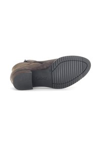 Bruine suède enkellaars met een zijrits, voorzien van een gestructureerde zwarte rubberen outsole en een blokhak voor stabiliteit. Gabor-logo zichtbaar.