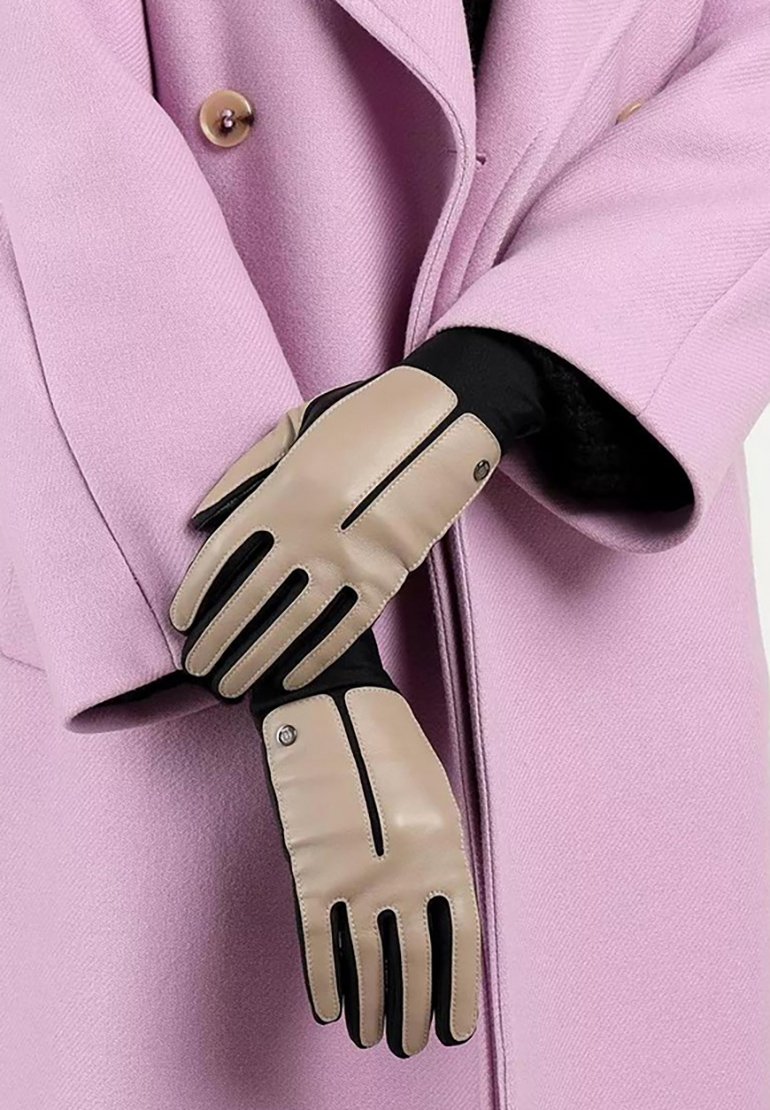 Beige Lederhandschuhe mit kontrastierenden schwarzen Akzenten und Steppnähten. Die Handschuhe haben ein elegantes Design und werden mit einem hellen lila Mantel getragen.