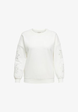 Balts džemperis ar garām, pūkainām piedurknēm, kurām apakšējās daļas rotātas ar izgrieztām ziedu dizainiem. Izgatavots no mīkstas, teksturētas auduma.