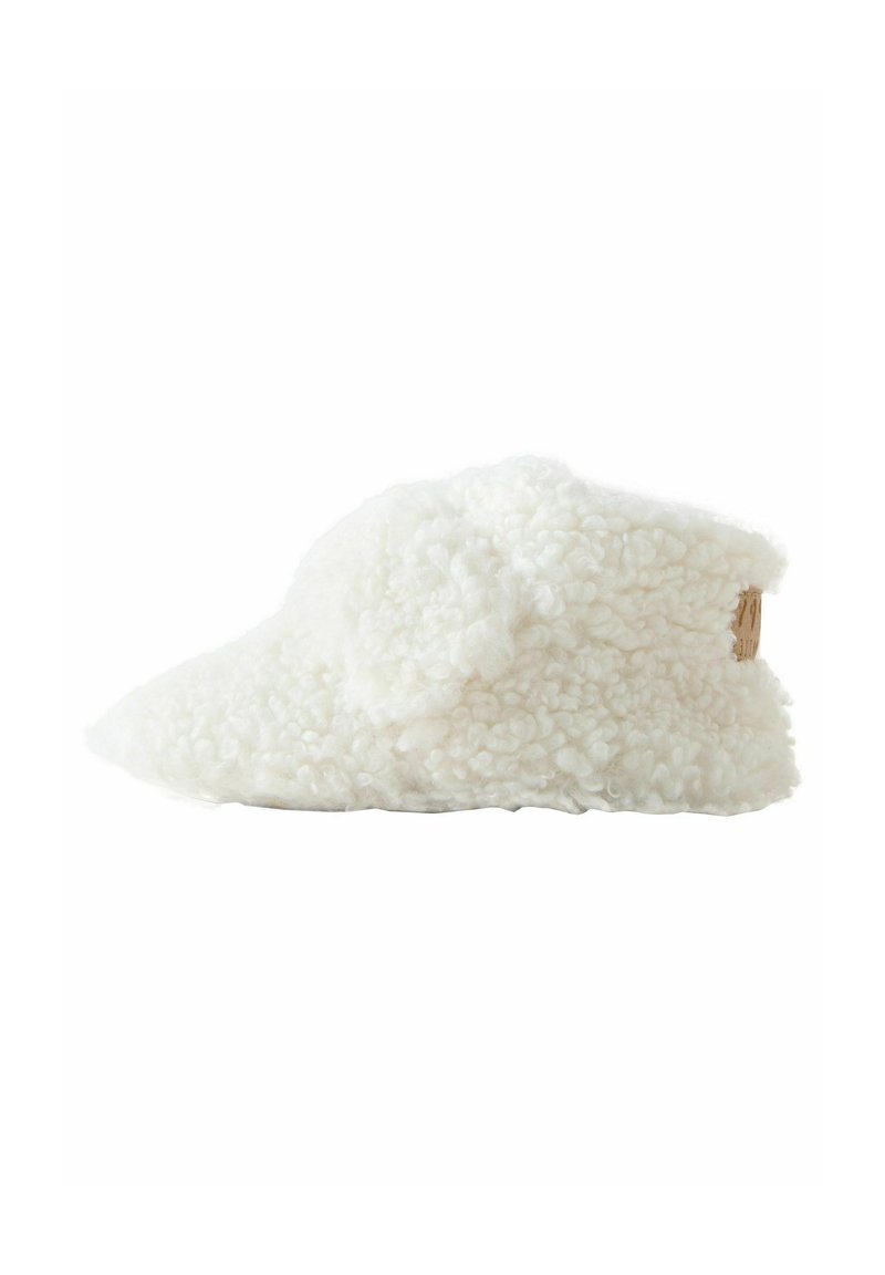 Vit toffel gjord av fluffigt, strukturerat material med en rundad, lågt profilform och en naturfärgad accent baktill.