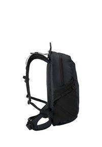 Mochila negra con correas acolchadas, bolsillo lateral con cremallera y correas ajustables de cintura y pecho, vista desde el lado izquierdo.