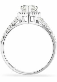 Bague avec un bandeau en argent poli, dotée d'une grande pierre centrale en diamant ovale et de petites pierres le long des épaules, mettant en valeur des découpes intriquées.