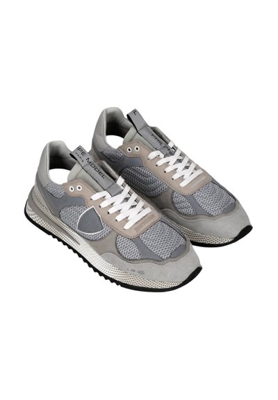 Sneaker sportive grigio e beige in materiali mesh e suede, con lacci bianchi, suola strutturata e un design a strati.