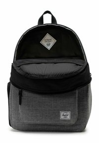 Sac à dos avec un corps tissé gris, un dessus noir et une fermeture éclair. Présente une poche avant et une étiquette en tissu à l'intérieur. Surface texturée. Bretelles ajustables.