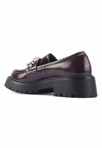 Mocasines de charol burdeos con un acento metálico y suela de goma negra gruesa con un profundo perfil para mayor tracción.