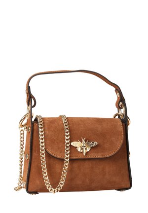 Sac à main en daim marron avec un fermoir abeille doré, une courte poignée en cuir et une longue bandoulière chaîne dorée sur fond blanc.