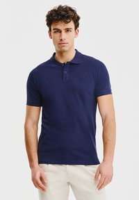 Granatowa koszulka polo z kołnierzykiem, krótkimi rękawami i dwoma guzikami. Wykonana z gładkiego materiału, z subtelnym logo na piersi.