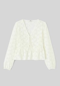 Blouse blanche à manches longues en dentelle avec motif floral, décolleté en V profond, deux liens à l'avant et ourlet évasé style peplum sur fond gris.