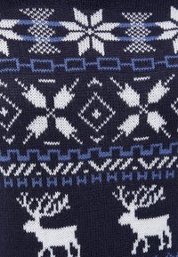 Tissu en maille bleu marine avec des motifs nordiques blancs et bleus, comprenant des flocons de neige, des formes géométriques et deux figures de rennes blancs.