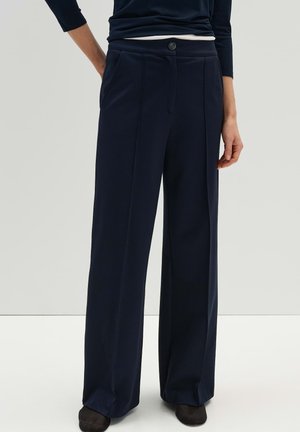 Marineblauwe wijde broek met voorzakken, een knoopsluiting en een zachte textuur. Kenmerkt zich door een platte voorkant en een getailleerd ontwerp.