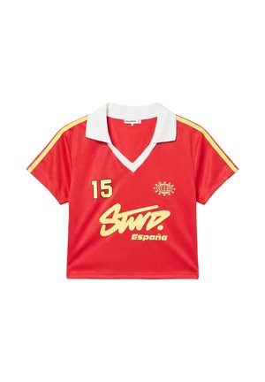 Červený športový crop top s krátkym rukávom, bielym golierom, žltými pruhmi na rukávoch, číslom 15 a nápisom "Spain" s logom glóbusu a hviezd.