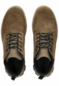 Botas de tobillo de ante marrón con cordones de patrón en blanco y negro, parte superior texturizada, suela de goma y una lengüeta en el talón.