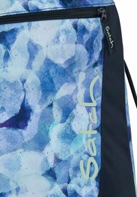 Blauer Rucksack mit gemustertem Design abstrakter Formen, versehen mit einem glatten schwarzen Stoffpaneel und einem Logo an der Seite.