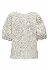 Blouse blanche texturée à manches courtes avec manches bouffantes et motif floral en relief couvrant le tissu.