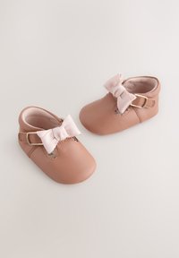 Chaussures bébé en cuir rose avec bout arrondi, ornées d'un nœud décoratif et d'accentuations en boucle dorée. Doublure intérieure douce pour un confort optimal.