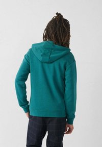 Sudadera azul verdosa de mezcla de algodón suave, con capucha ajustable por cordón, puños y dobladillo acanalados. La vista trasera muestra un diseño simple.