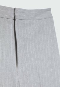 Světle šedé látkové kalhoty s vertikálními bílými proužky, s plochým pasem a hladkým povrchem. Viditelný detail postranního švu.