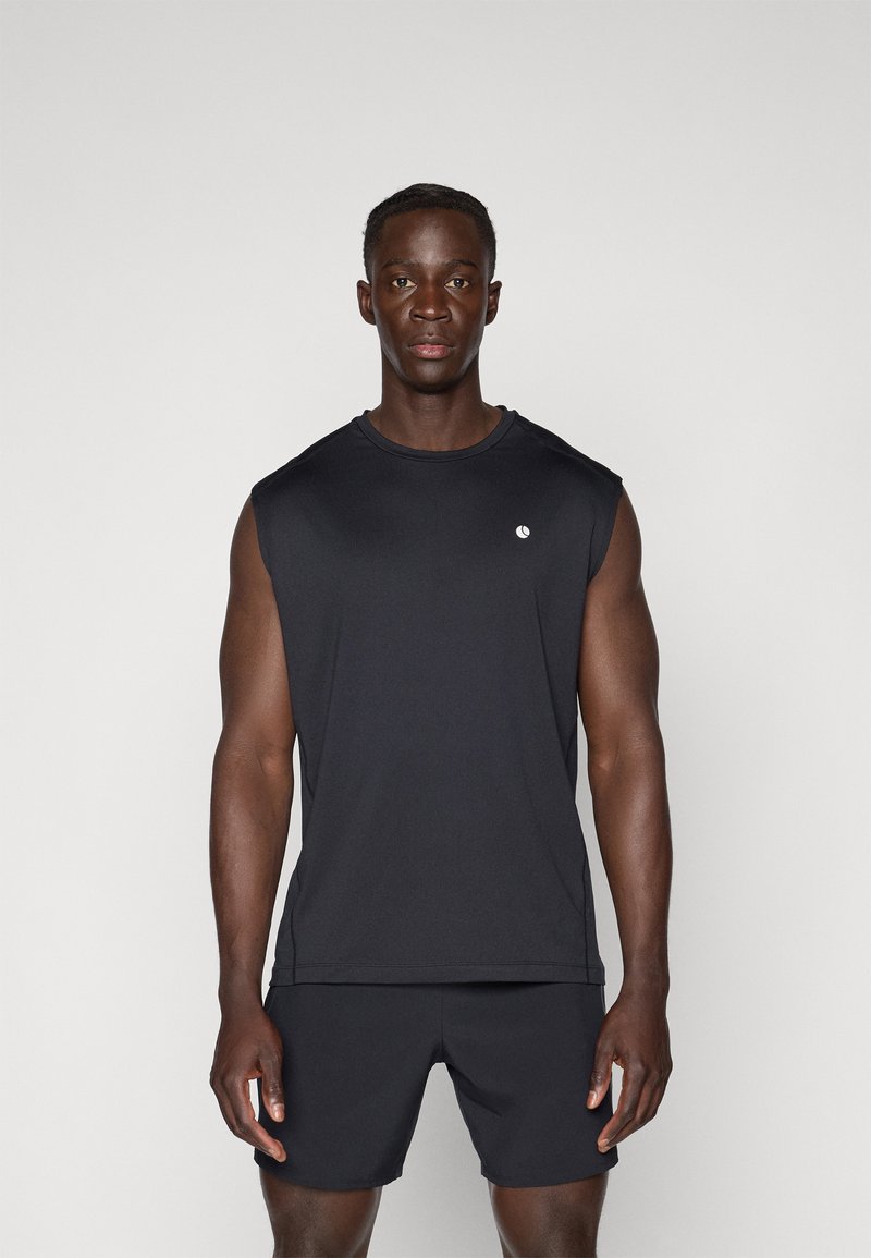 Čierny bezrukávový športový top z ľahkej tkaniny, s jemným logom na hrudi. V kombinácii s čiernymi šortkami.