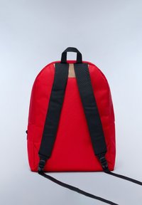 Zaino rosso con spallacci neri, forma arrotondata e una piccola maniglia superiore. Realizzato in tessuto liscio con un design minimalista e senza dettagli visibili.