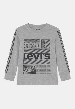 Grå langærmet Levi's skjorte med sort trykt tekst og striber, herunder "Established 1873 San Francisco, California" og "Quality Clothing."