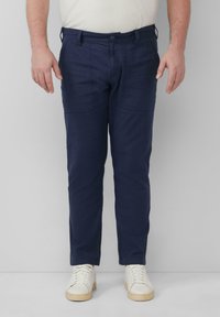 Navyblauwe katoenen broek met een slim fit, twee voorszakken en een rechte voorkant, gecombineerd met witte sneakers.
