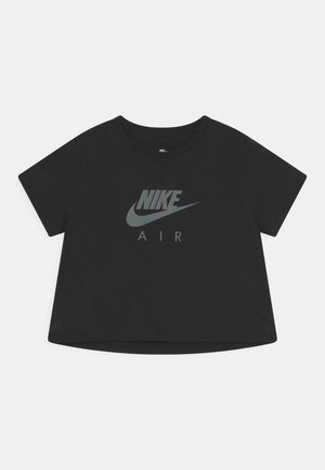 Crop top noir à manches courtes avec logo Nike Air gris centré sur le devant, sur fond uni.