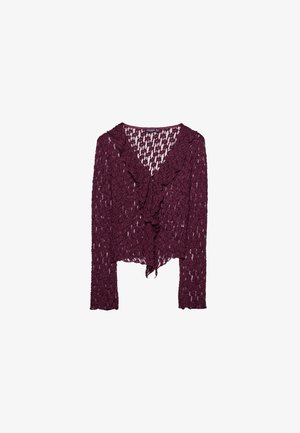 Cardigan a maniche lunghe di pizzo viola scuro con bordi frontali arricciati e un motivo floreale semitrasparente.